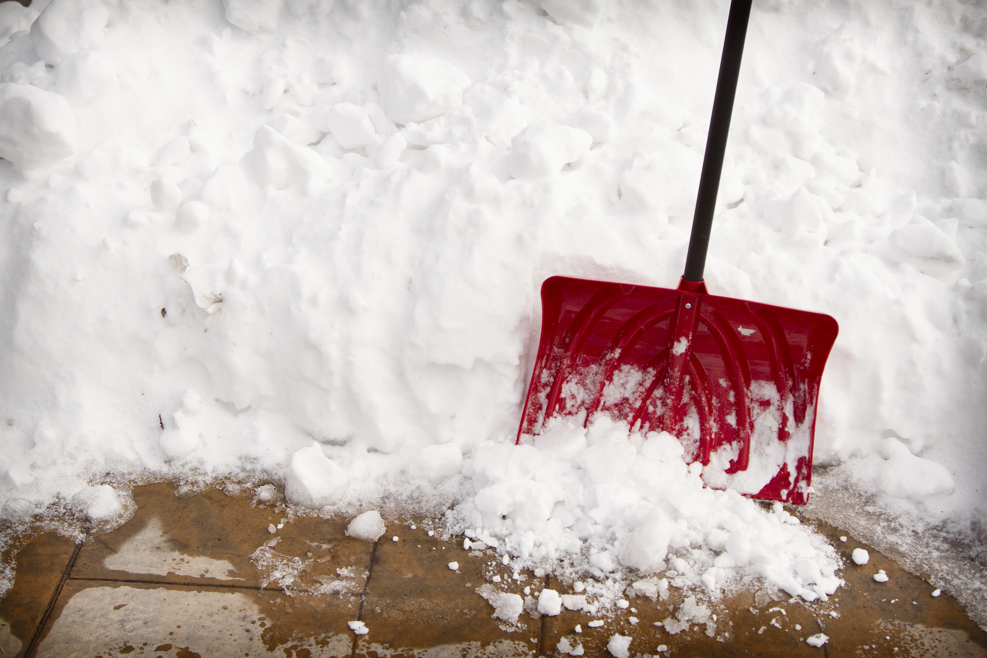 How should you prepare your parking lots and sidewalks for snow?