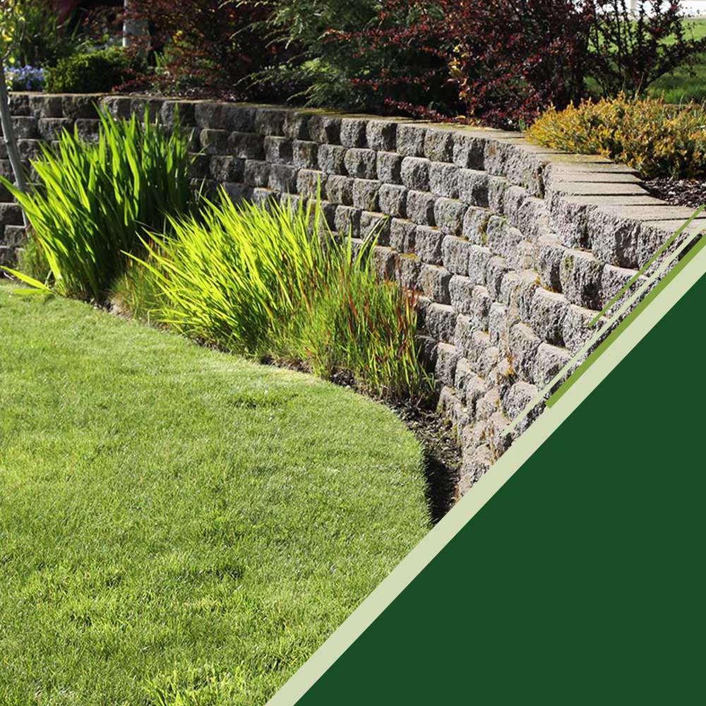 retaining wall with plants frames grassy yard