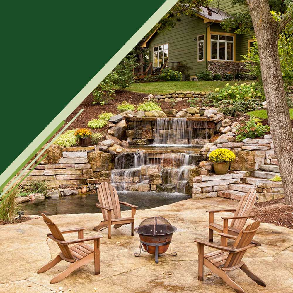 Chairs and fire pit area with waterfall and home in the background